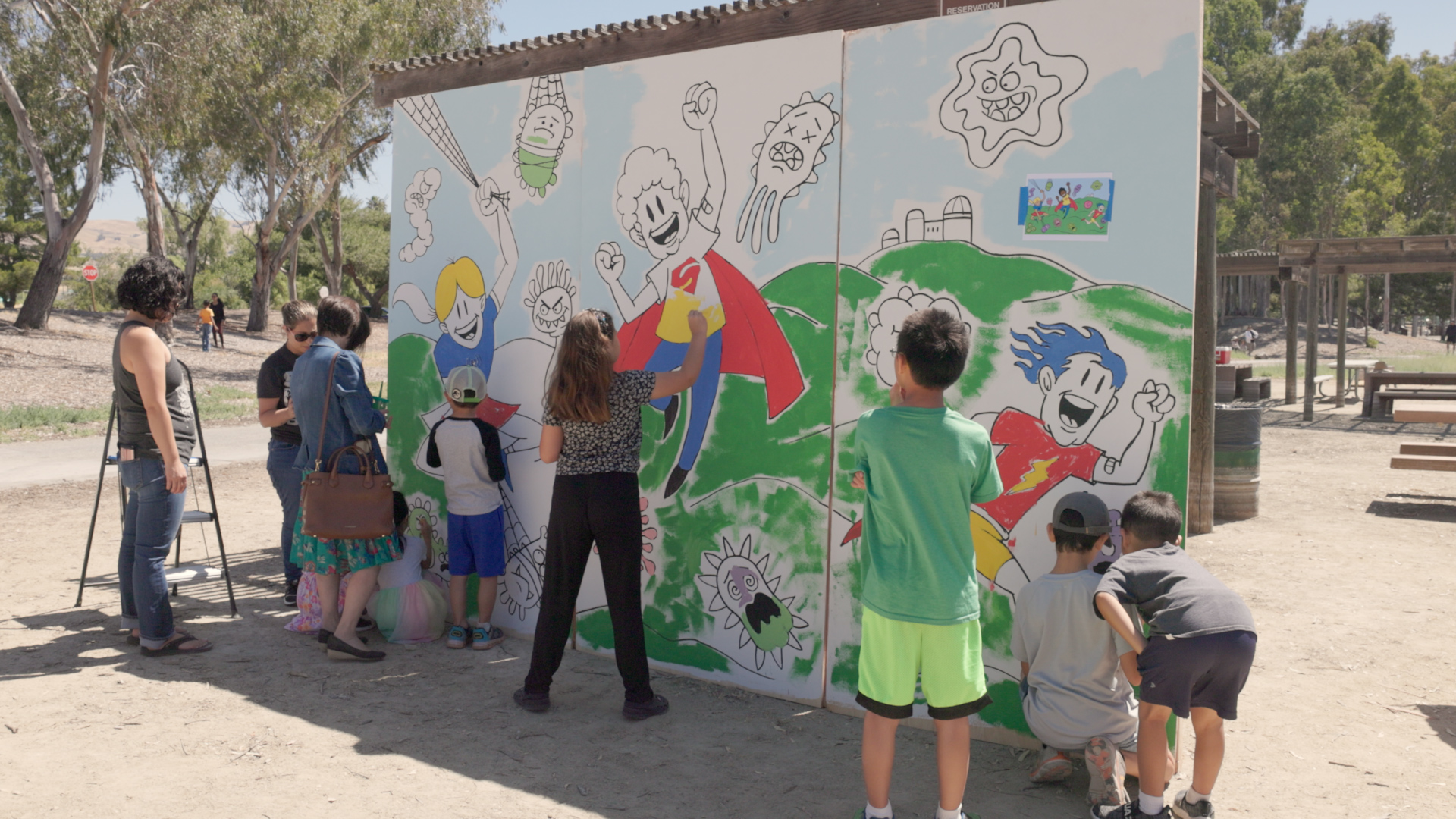 children painting mural outdoors