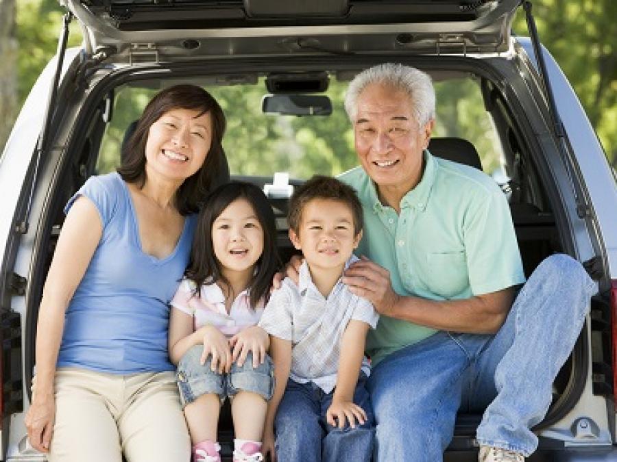 A family sitting in the trunk of a van.