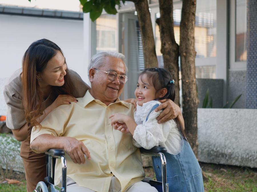 坐在輪椅上的老爺爺跟女兒和孫女在一起