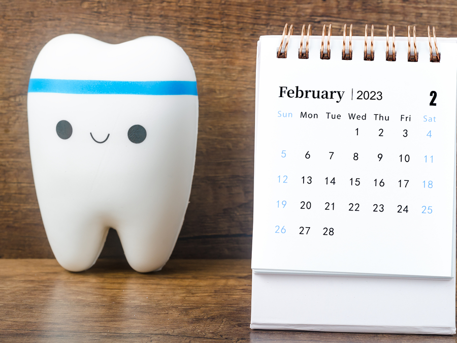 Smiling Tooth Figure Next to a Flip Calendar