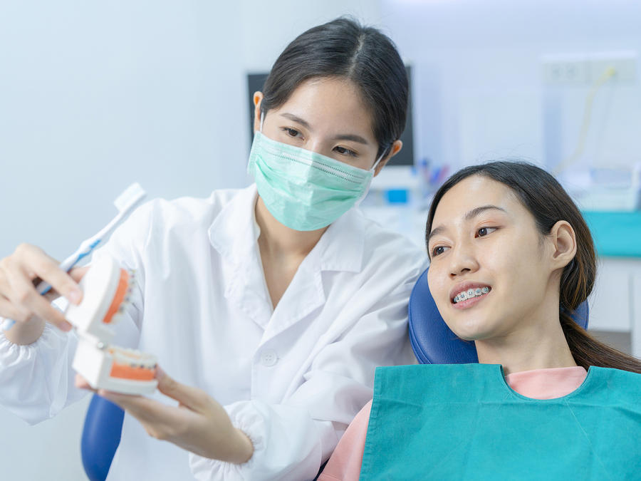 Dentist showing a set of fake teeth to a patient