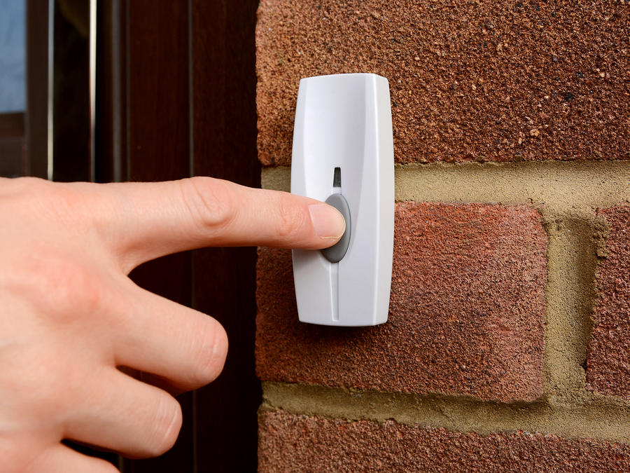 finger pressing doorbell