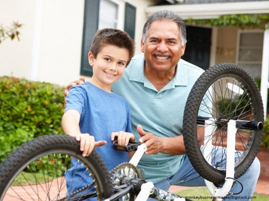A man and his grandson posed with a bike.