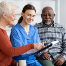 In-home nurse talking to elderly clients